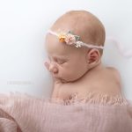 schlafendes Baby in rosa mit Haarband bei ihrem ersten Shooting