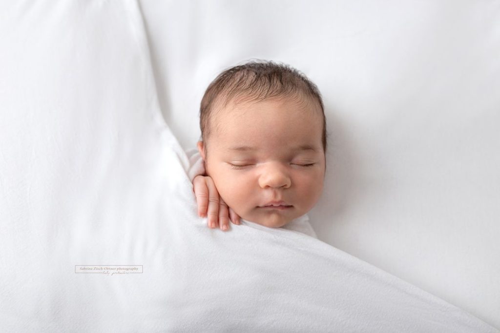 schlafendes frischgeschlüpftes Baby beim Fotoshooting