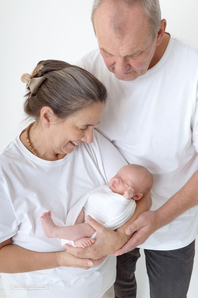 strahlende Großeltern und ihre Enkelin beim Babyshooting