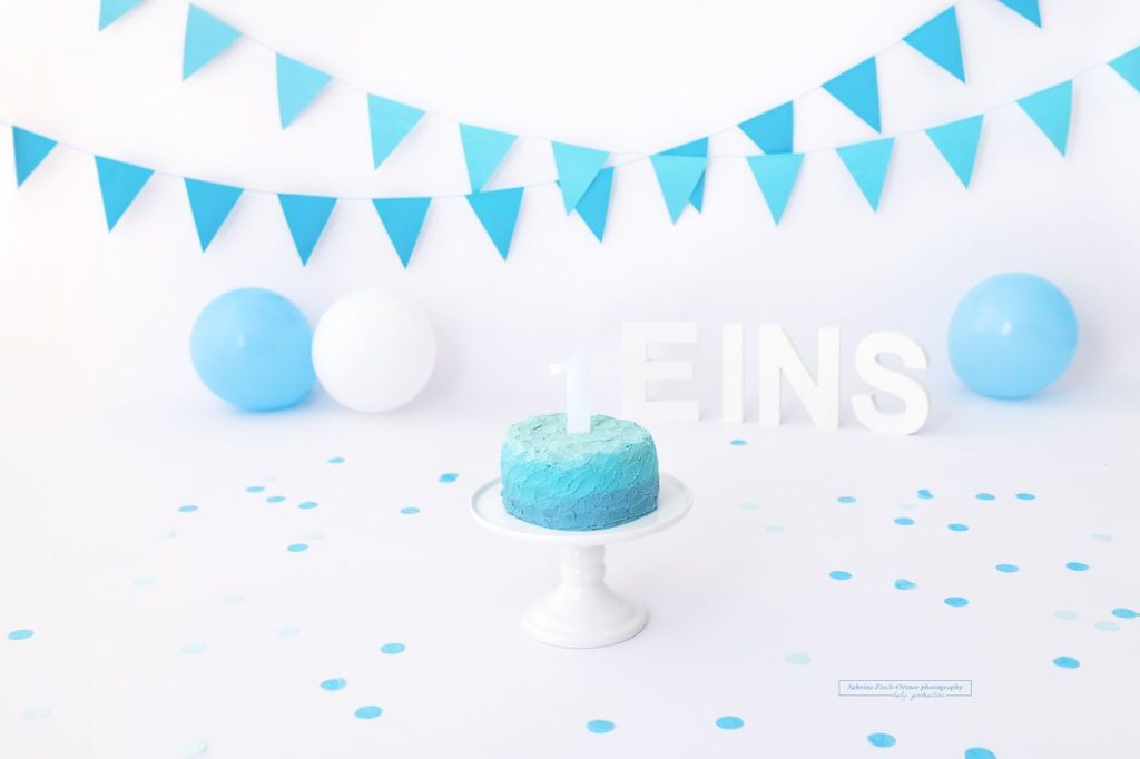 Cake Smash Geburtstags Setup in blau weiß mit Torte Luftballons und Wimpelkette