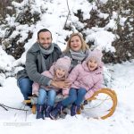Familienfoto mit Rodel im Winter mit Schnee