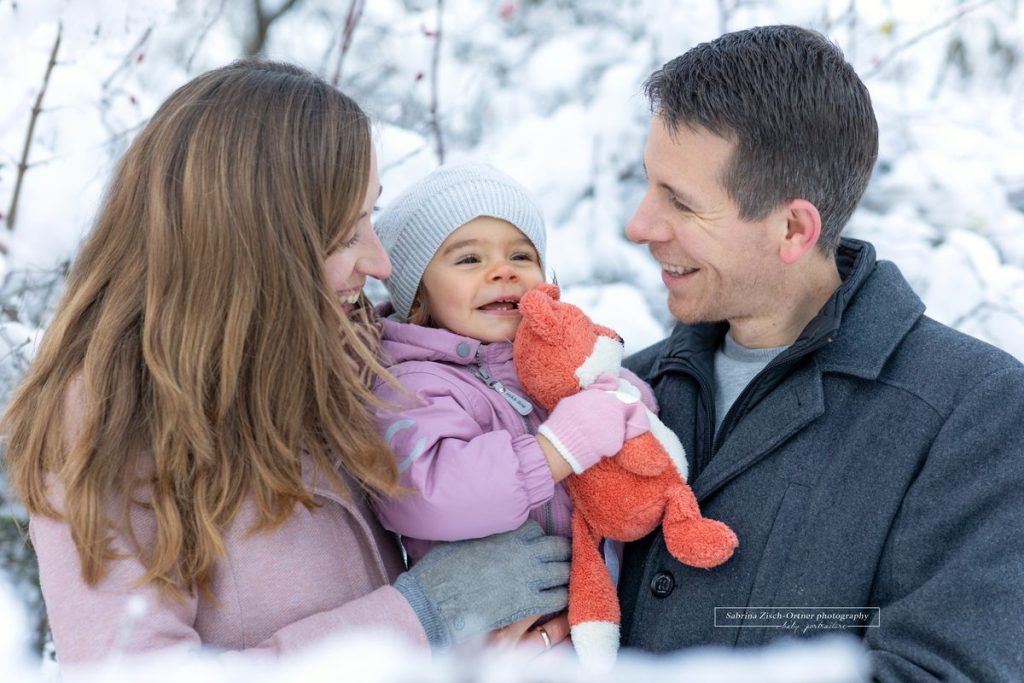 grinsendes Familienfoto in den dicken Winterjacken