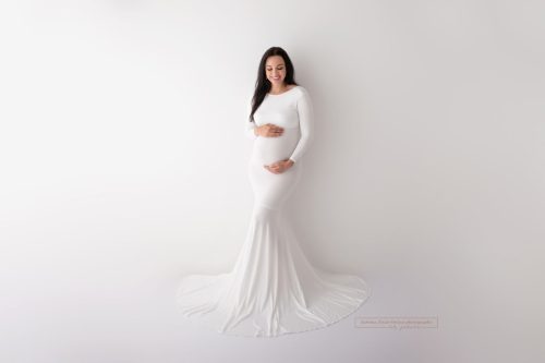 Brasilianische Schwangere im weißen Babybauchkleid