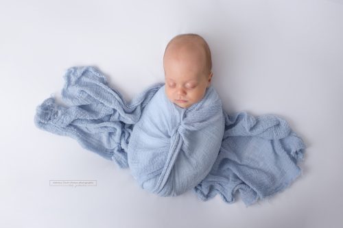 Baby eingewickelt in blaues Tuch