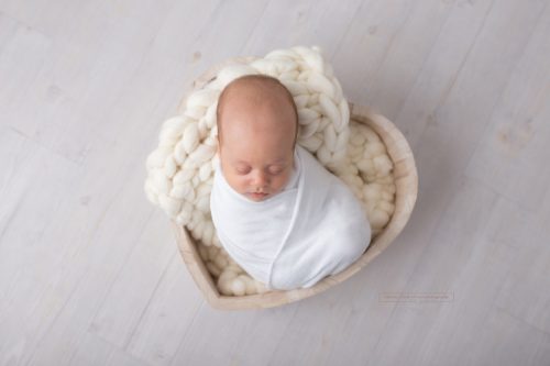 Baby in Herzschale liegend bei seinem ersten Fotoshooting