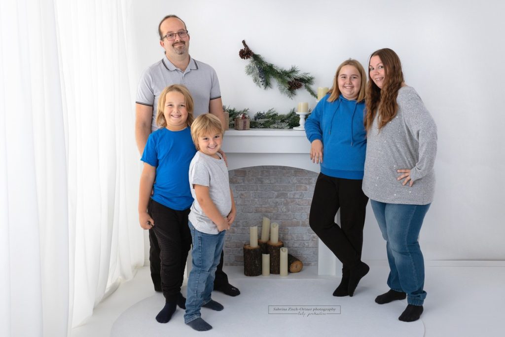 Eltern und Kinder grinsen für ihr Familienfoto in die Kamera