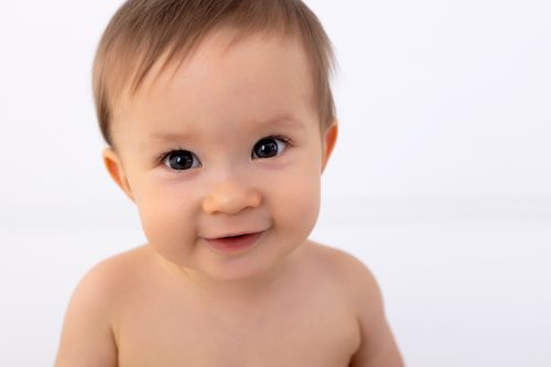 Portraitaufnahme sieben Monate jungem Burschen bei seinem Meilenstein Baby Fotoshooting