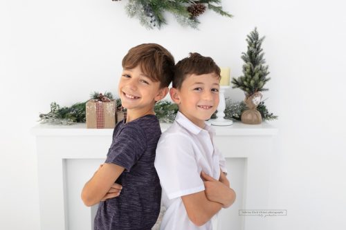 Schulkinder spielen brav mit bei ihren jährlichen Weihnachtsfotos im Fotostudio