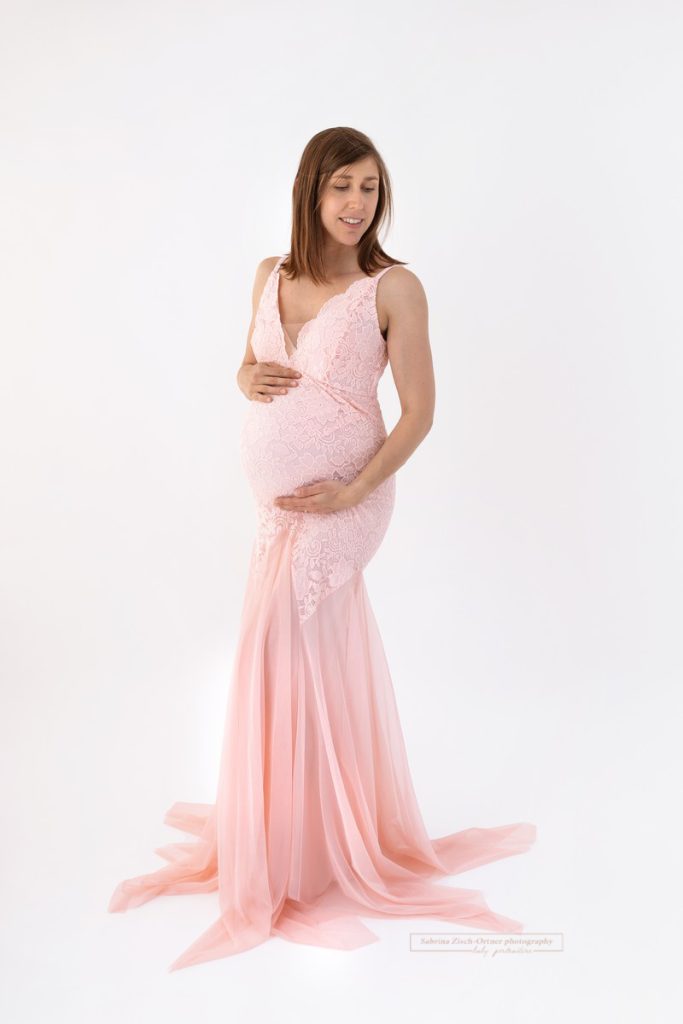 Schwangerschaft mit Fotos festhalten in rosa Kleid aus Spitze