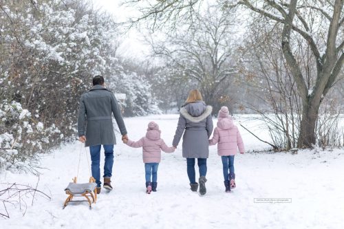 Vierköpfige Familie geht im Schnee spazieren
