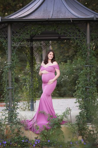 perfekt durch Blumen Pavillon eingerahmtes Schwangerschaftsfoto beim Outdoor Babybauch Shooting