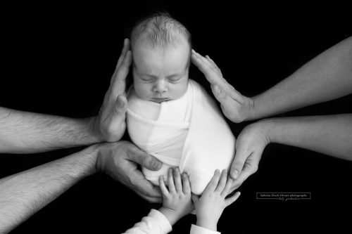 Baby mit Geschwisterchen und Eltern in Schwarz Weiß