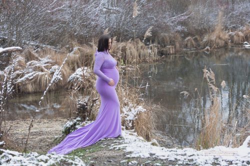 perfekte Zeitpunkt um Babybauch Fotos zu machen Winter Schnee Babybauch Naturfotos im lila Kleid