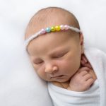 Baby mit Haarband speziell für Regenbogen Babys