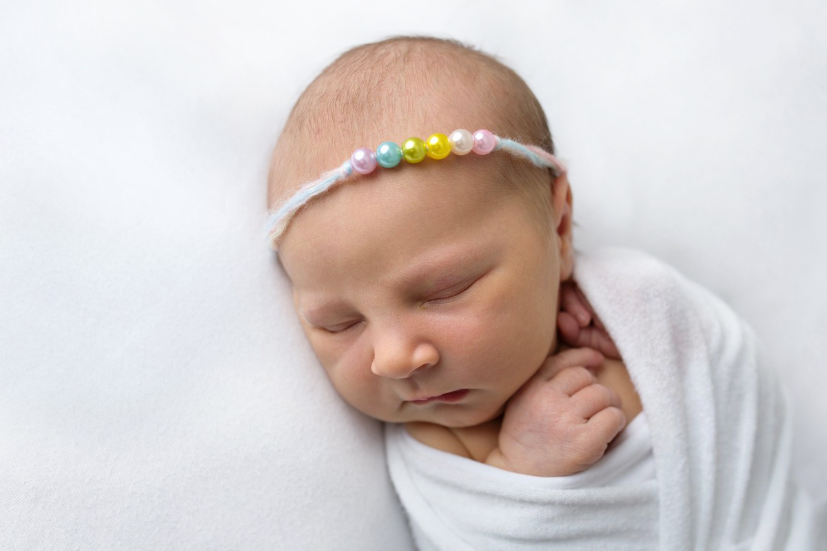 Baby mit Haarband speziell für Regenbogen Babys
