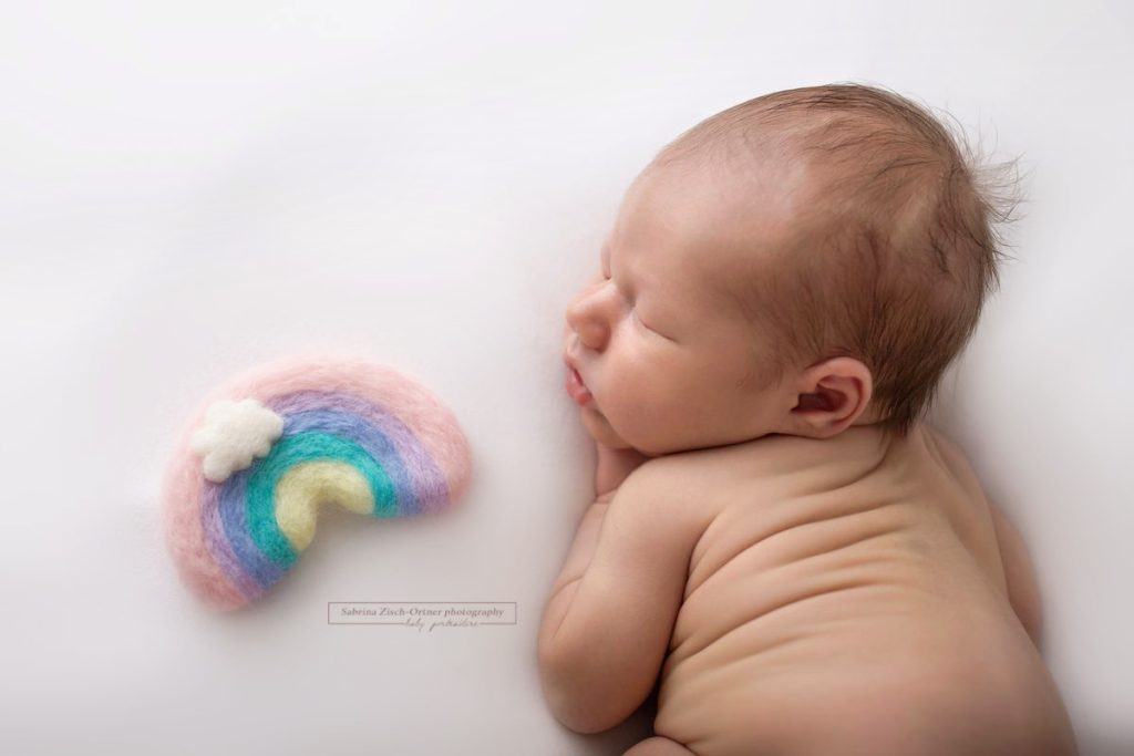 Baby neben einem Regenbogen aus Filz gemacht