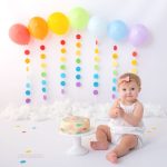 Luftballons in Regenbogenfarben und bunte Torte beim Geburtstags Fotoshooting
