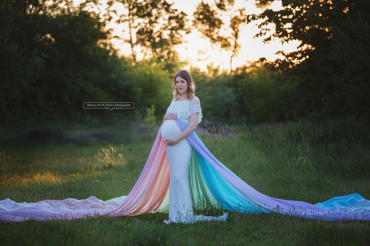 Schwangere mit Regenbogenbaby und Rock in Regenbogenfarben