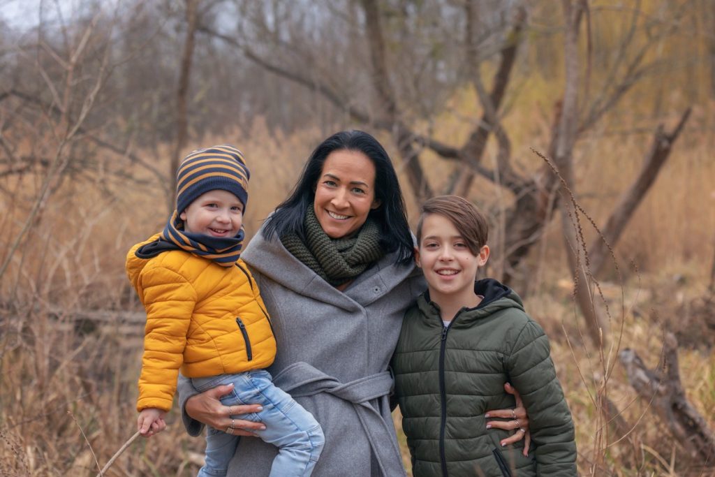 Mama umarmt ihre Kinder für Familienfotos vom Fotografen