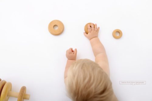 Holz Spielzeug und kleine Kinder Hände festgehalten für Meilenstein Fotos